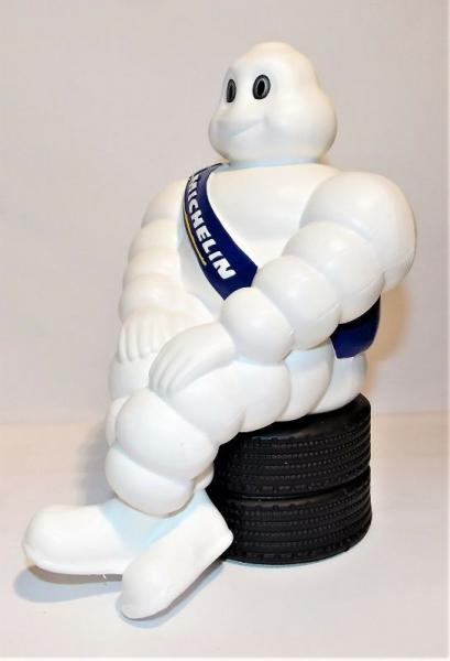 Michelin Männchen, sitzend auf Reifen